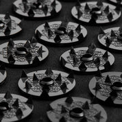 Close-up of Level 4 Shakti spikes with geometric designs on a textured surface